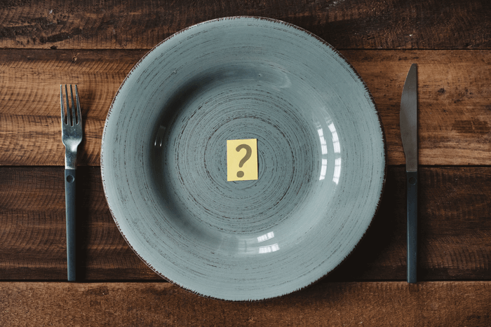 Assiette vide avec un point d’interrogation entre fourchette et couteau