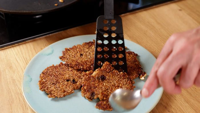 Galettes dorées déposées dans une assiette avec une spatule