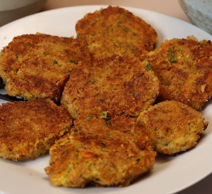 Galettes rondes dorées, panées et parsemées d’herbes