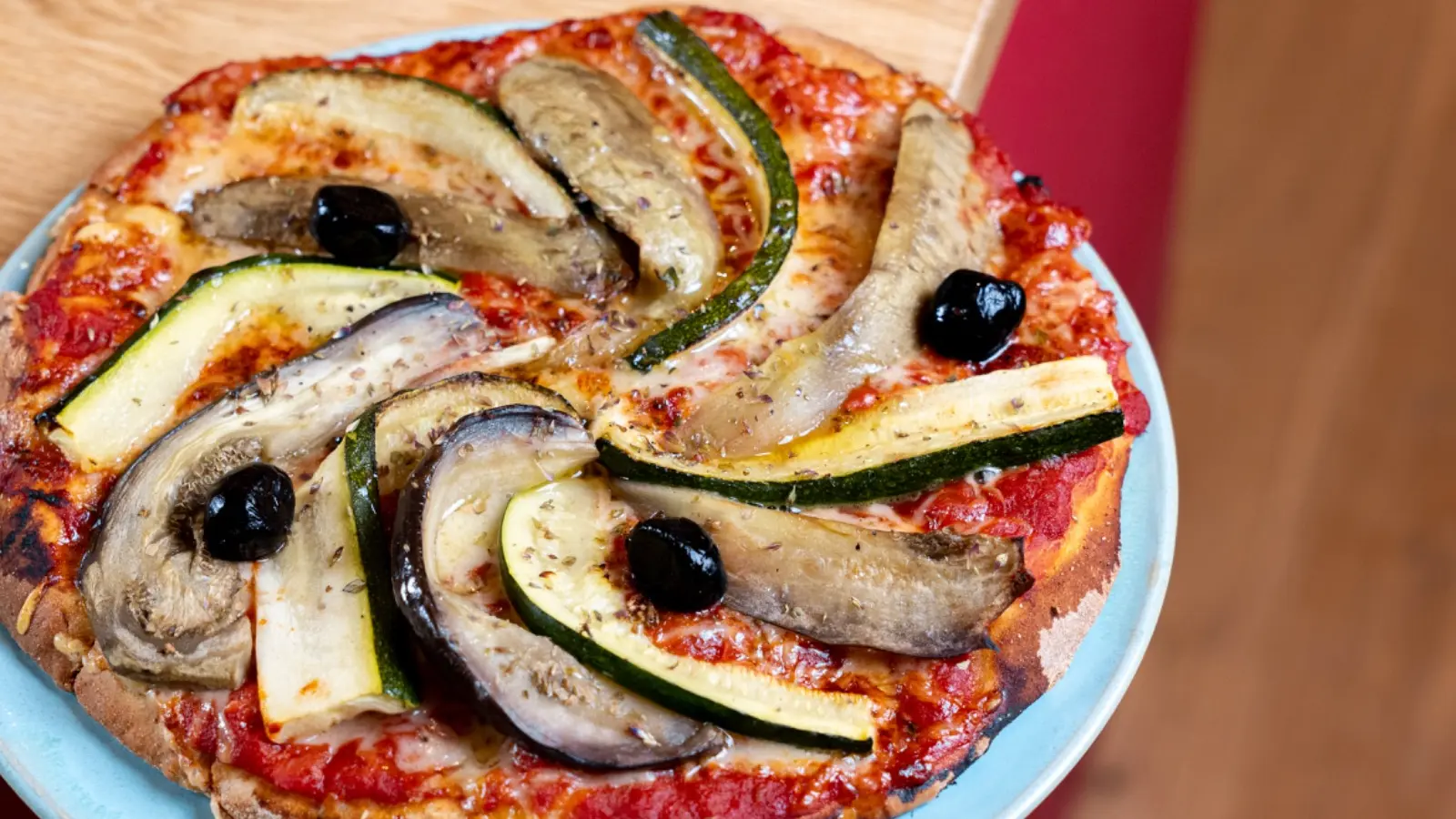 Pizza garnie d’aubergines, de courgettes et d’olives