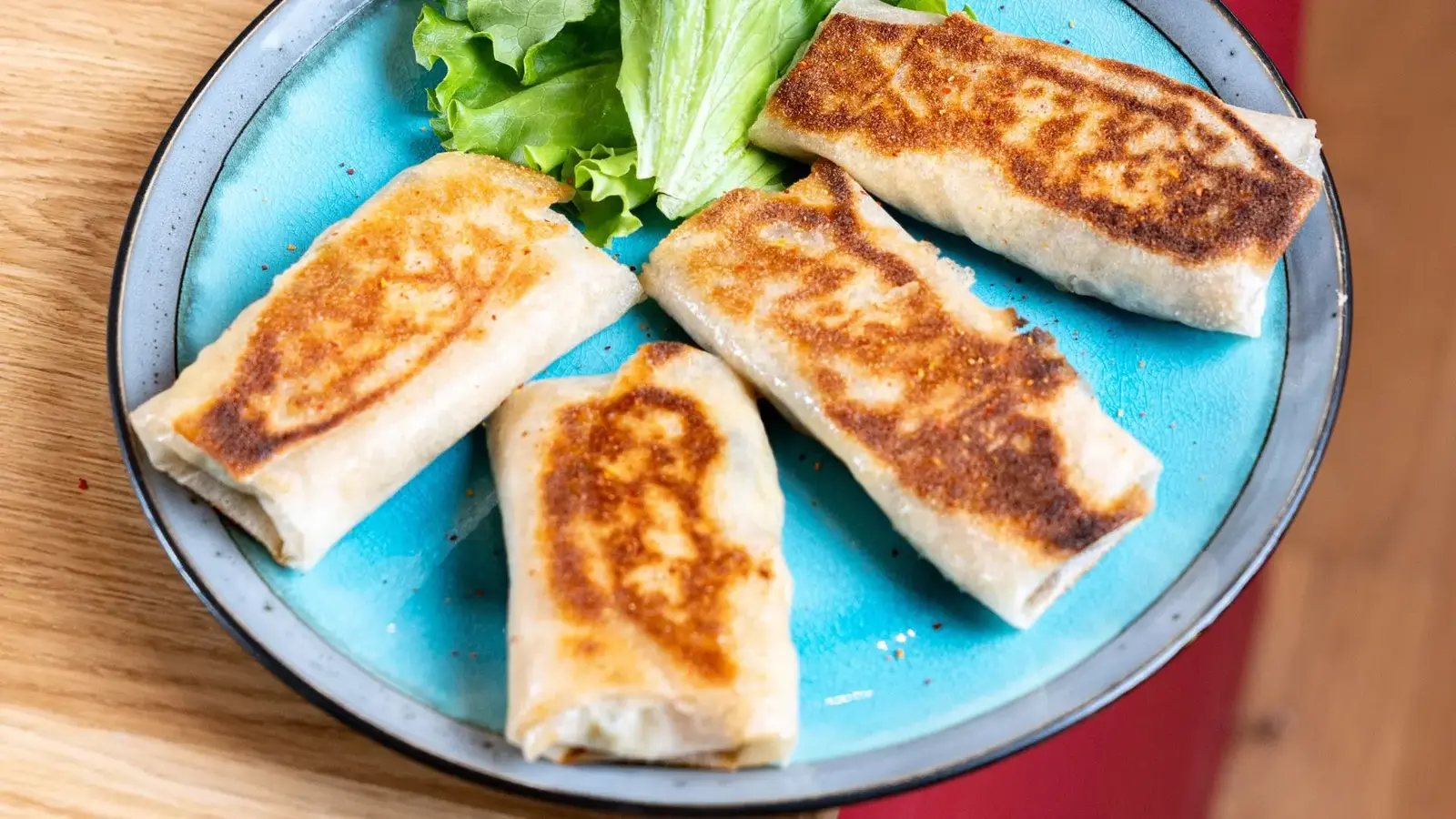 Rouleaux de feuilles farcies dorés servis avec une salade