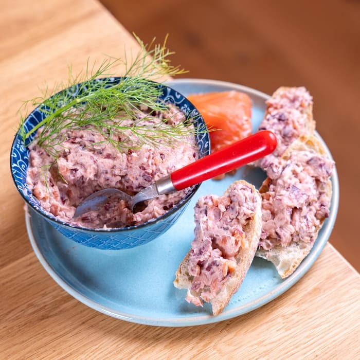 Tartinade rose aux herbes servie avec des tranches de pain