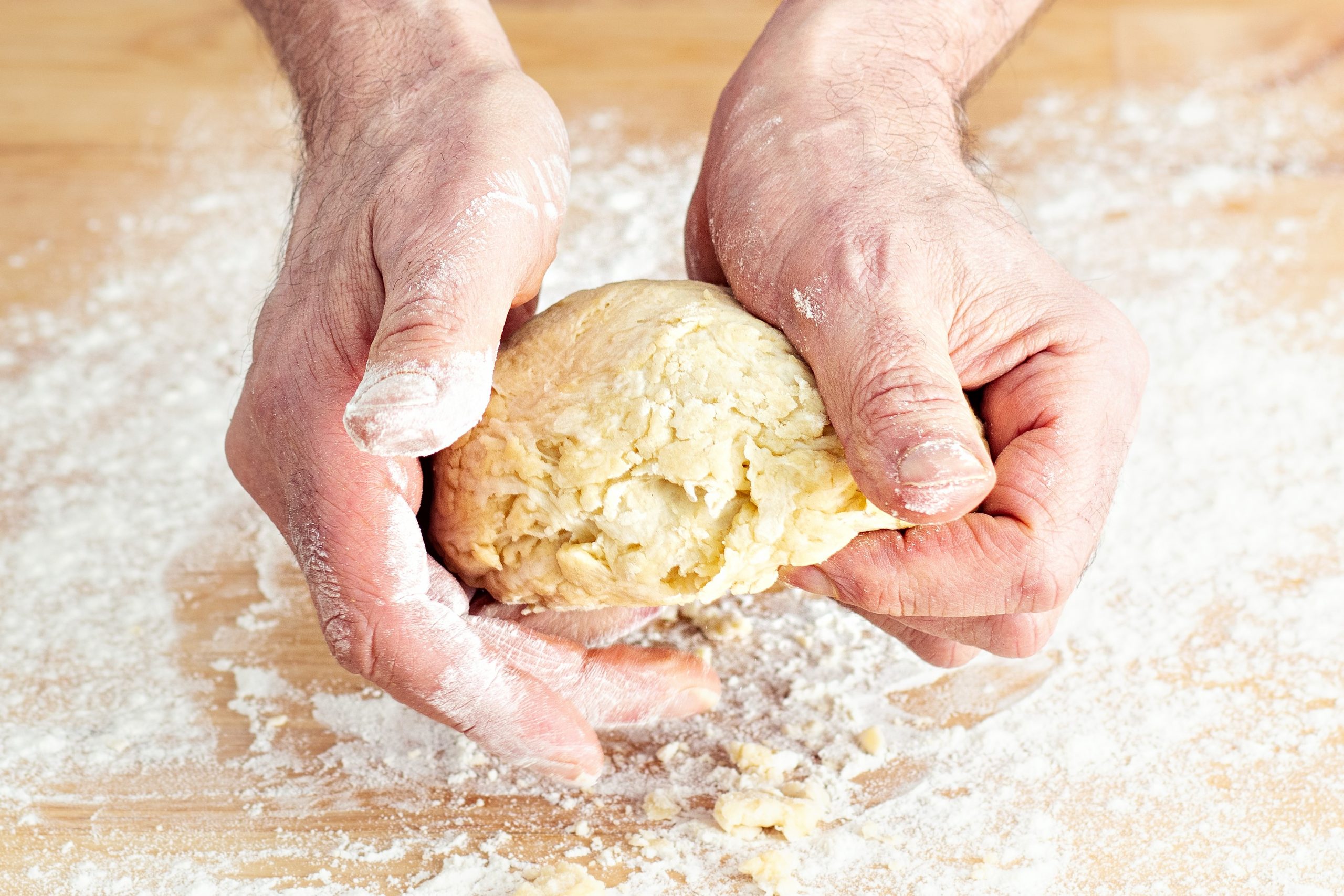 Mains qui pétrissent une pâte lors d'un atelier de cuisine
